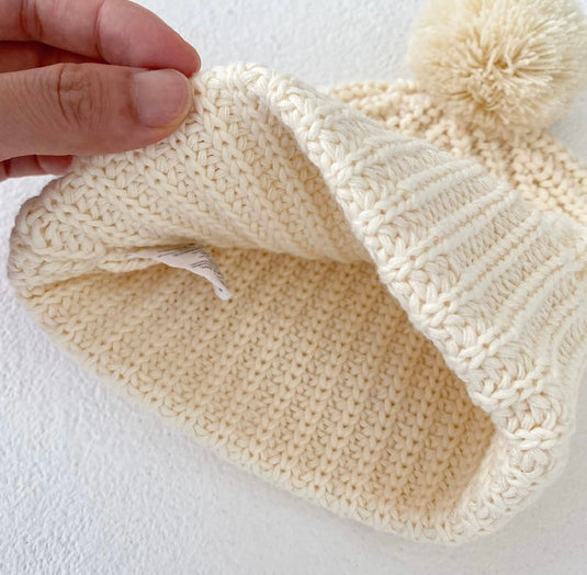 Bonnet bébé en tricot ivoire avec pompon en coton doux – Kali